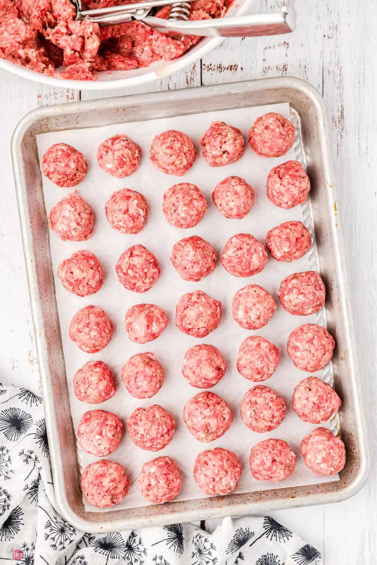 unbaked meatballs on a baking sheet