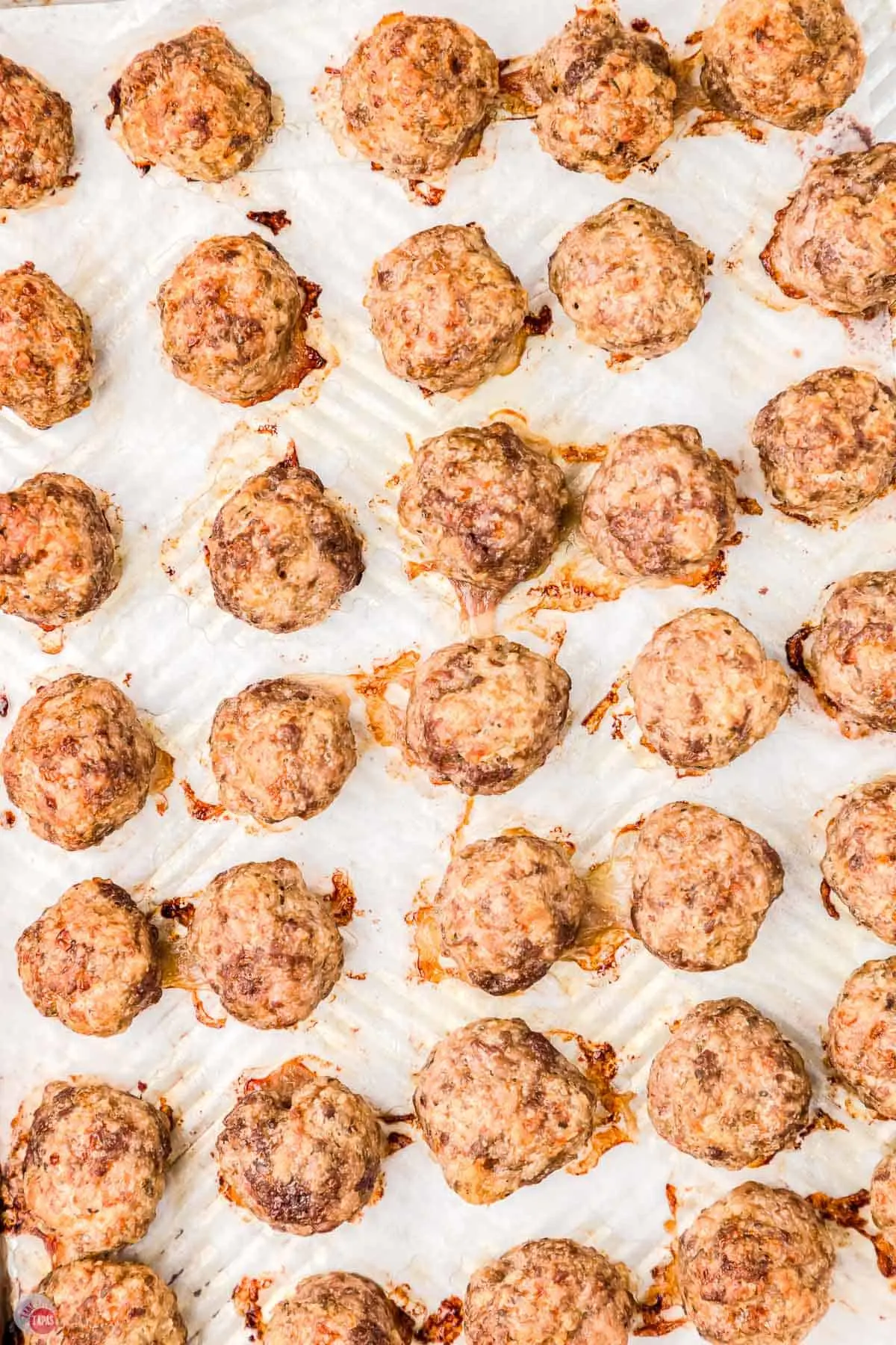 close up of baked meatballs on parchment paper