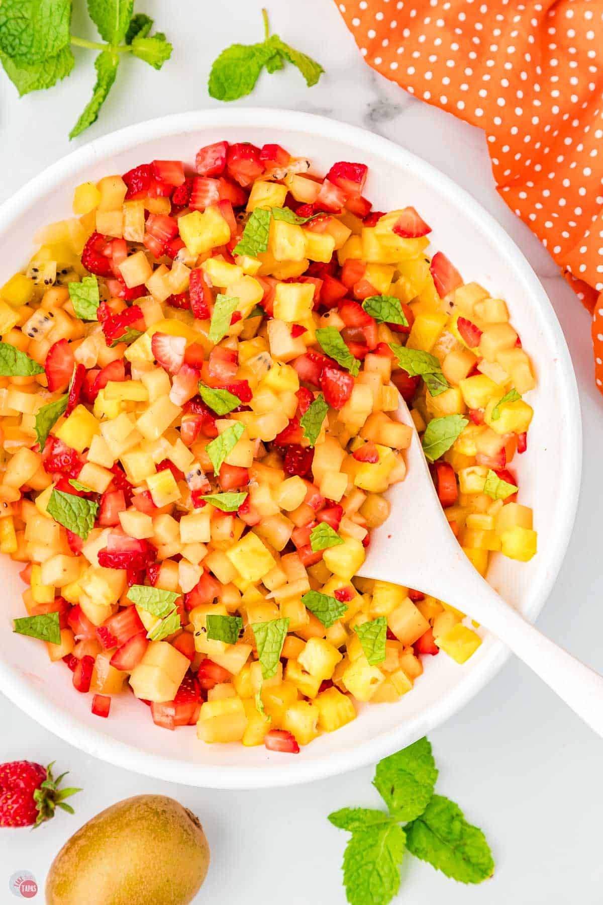 batch of fruit salsa with a spoon and orange napkin