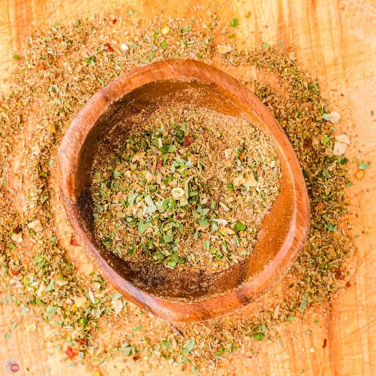 wood bowl with pizza seasoning spread in it.