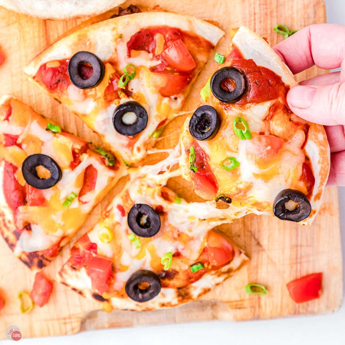 mexican pizza being pulled with a hand