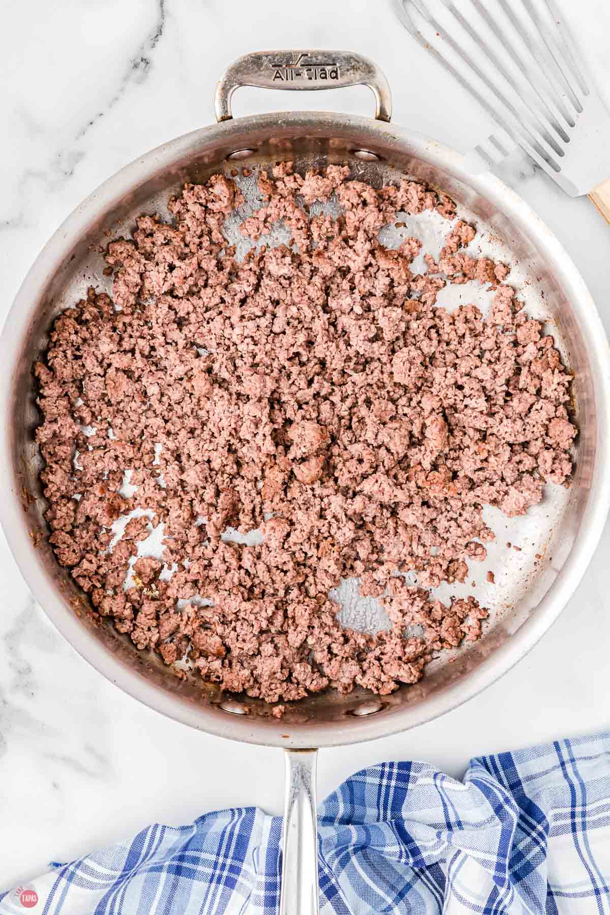 ground beef cooking in a silver skillet
