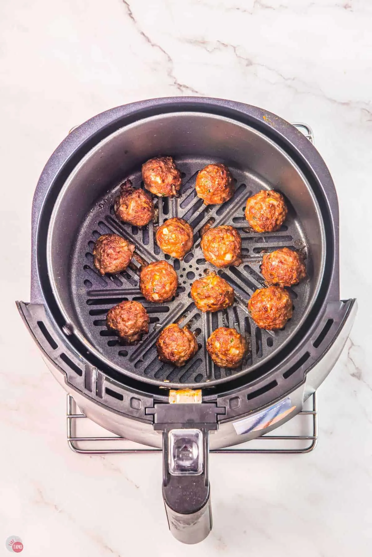 beef meatballs in an air fryer basket already cooked