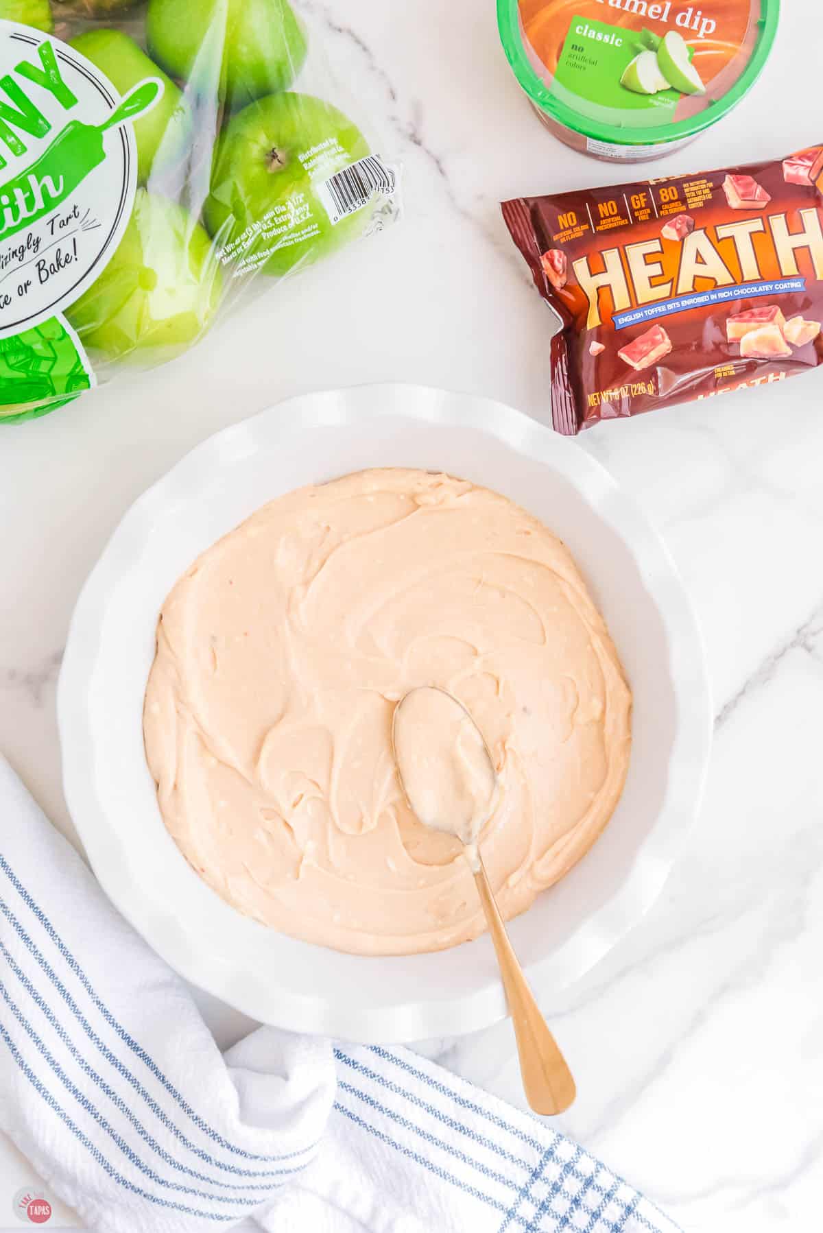 cream cheese mixture being spread into pie plate