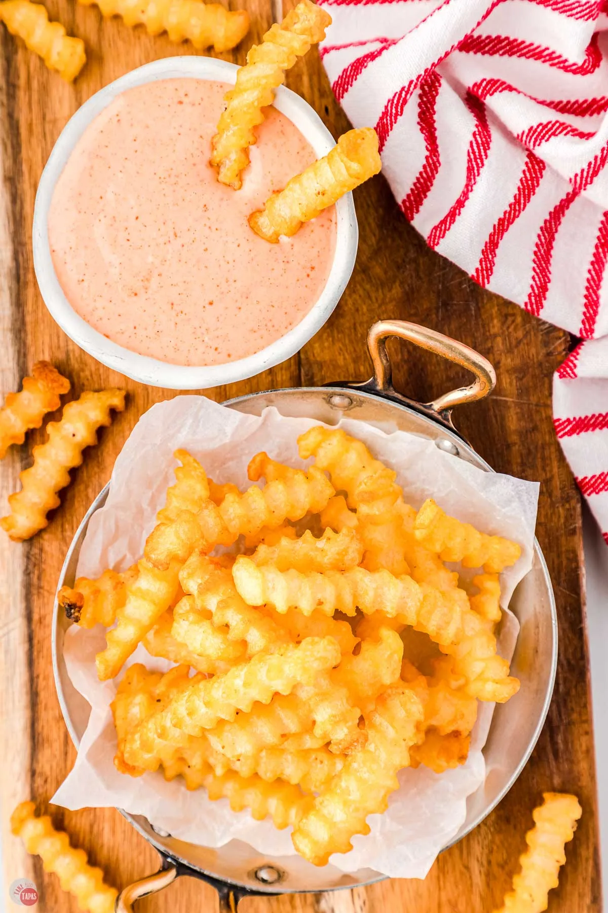 plate of french fries next to red and white napkin