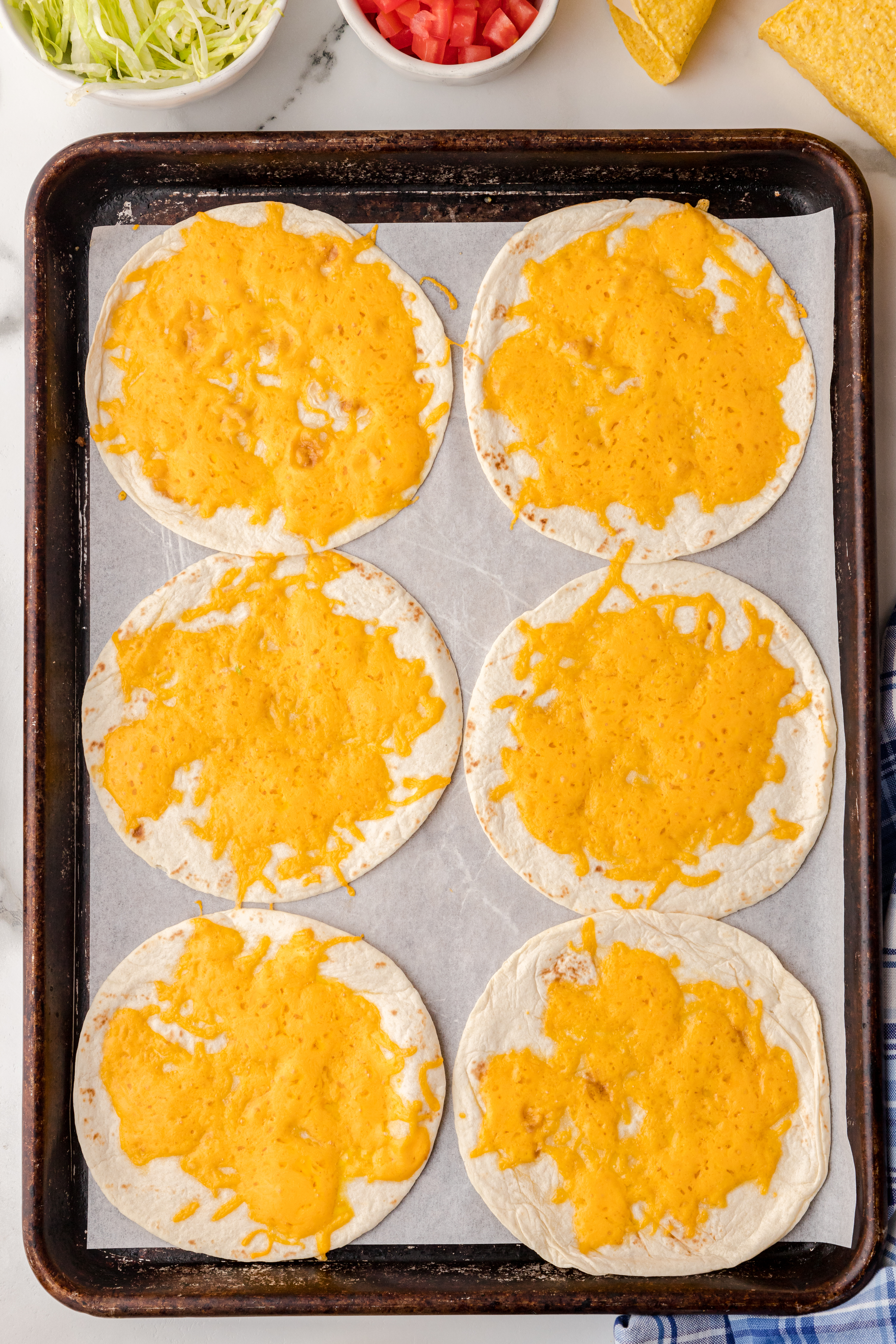 cheesy flatbread on a baking sheet