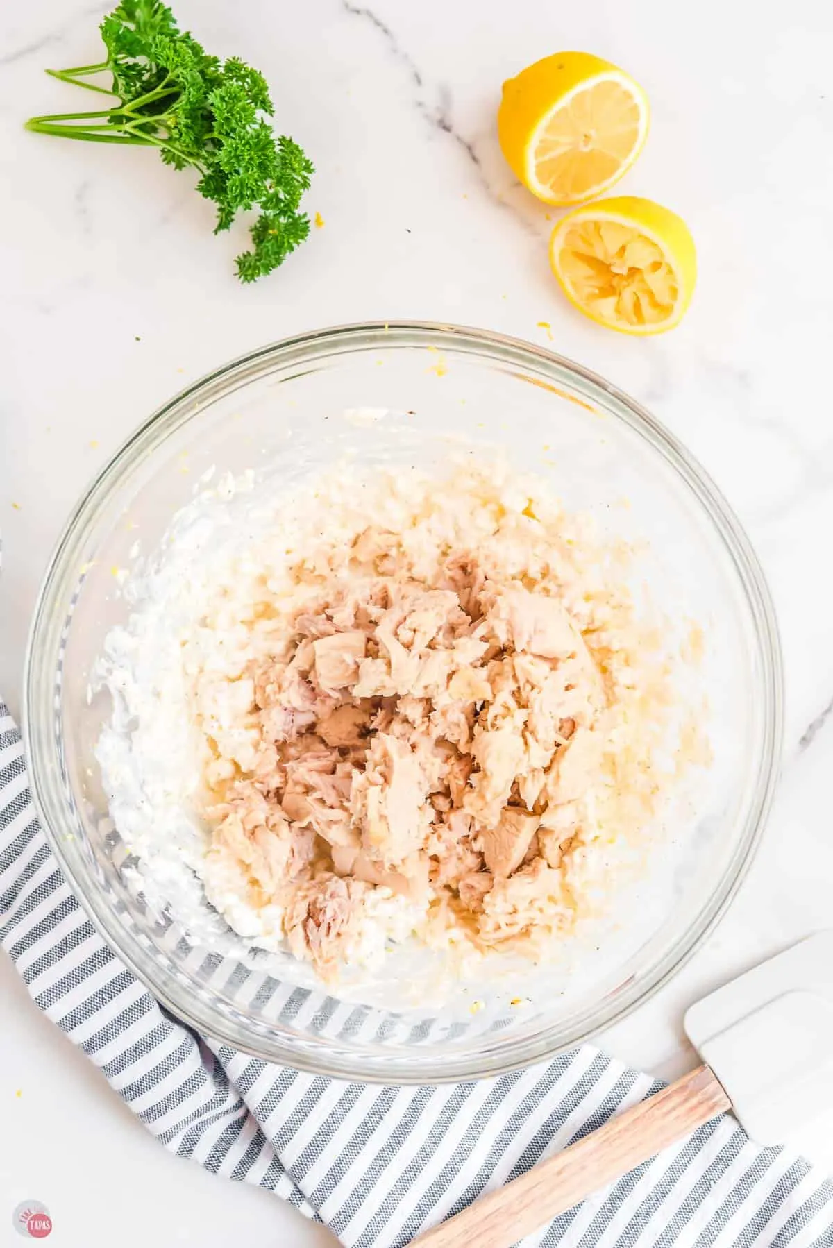 cans of tuna on top of cream cheese in a bowl