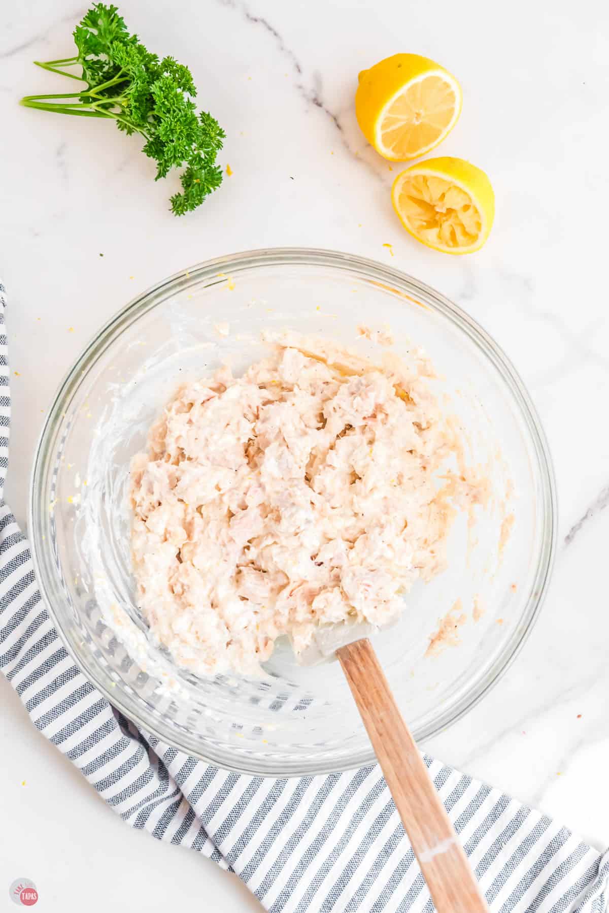 drained tuna being mixed with a spatula