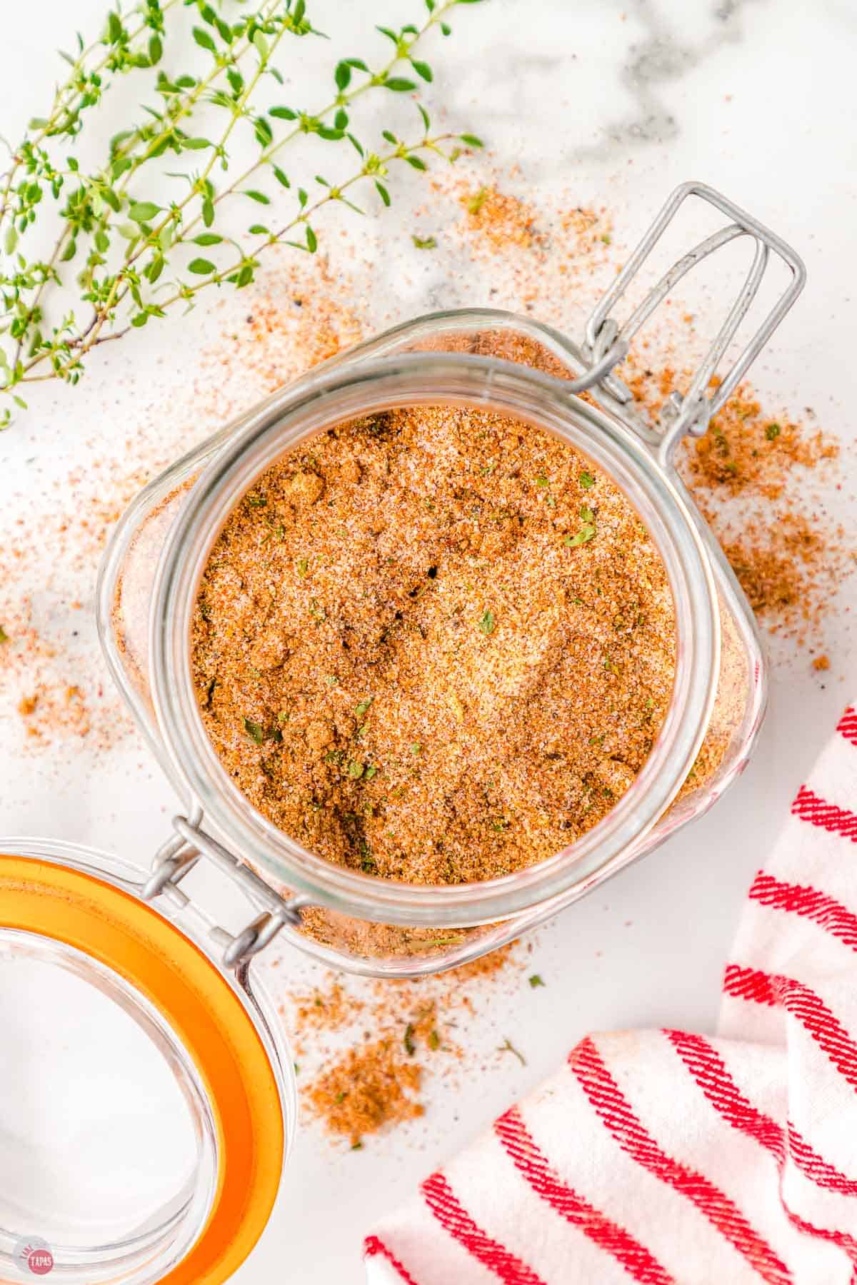 jar of bbq seasoning next to a red and white striped napkin
