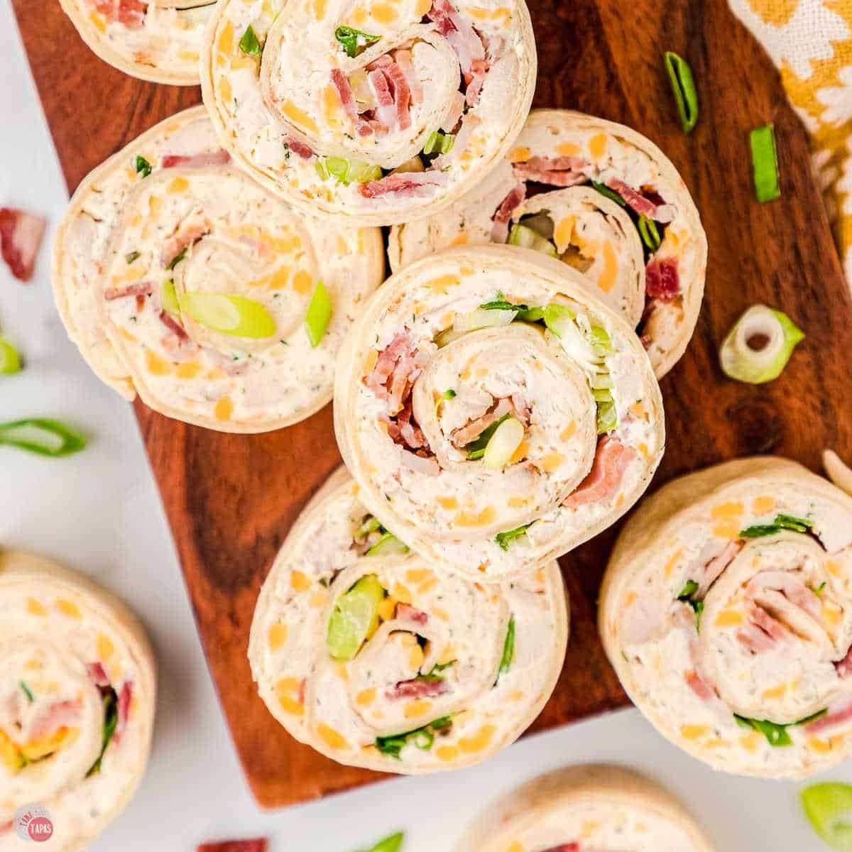 chicken bacon ranch pinwheel sandwiches on a wood board