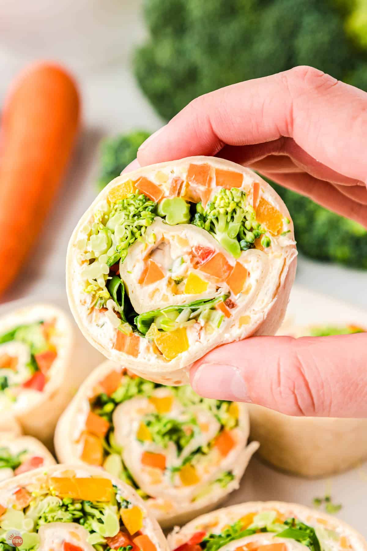 hand holding a veggie pinwheel sandwich