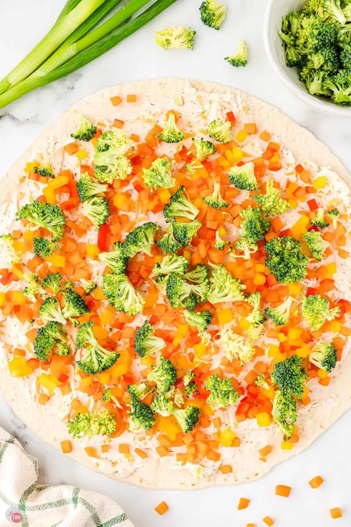 finely chopped broccoli and bell peppers on a tortilla