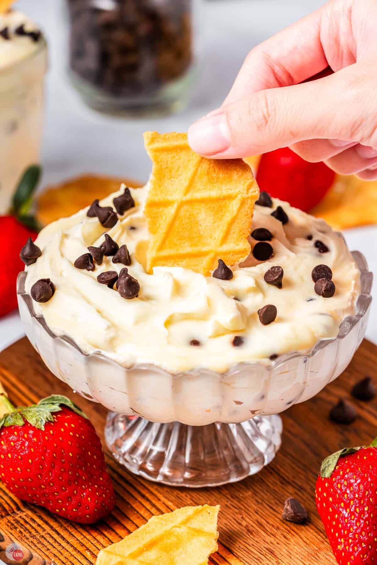 glass jar of cannoli dip with a broken piece of waffle cone