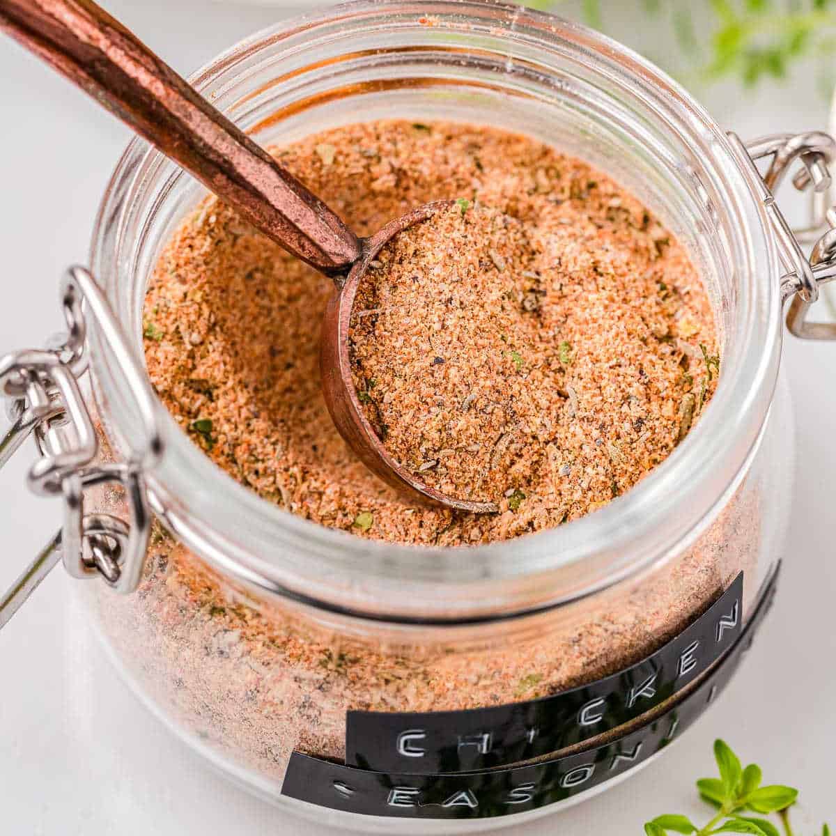 small jar of chicken seasoning with copper spoon