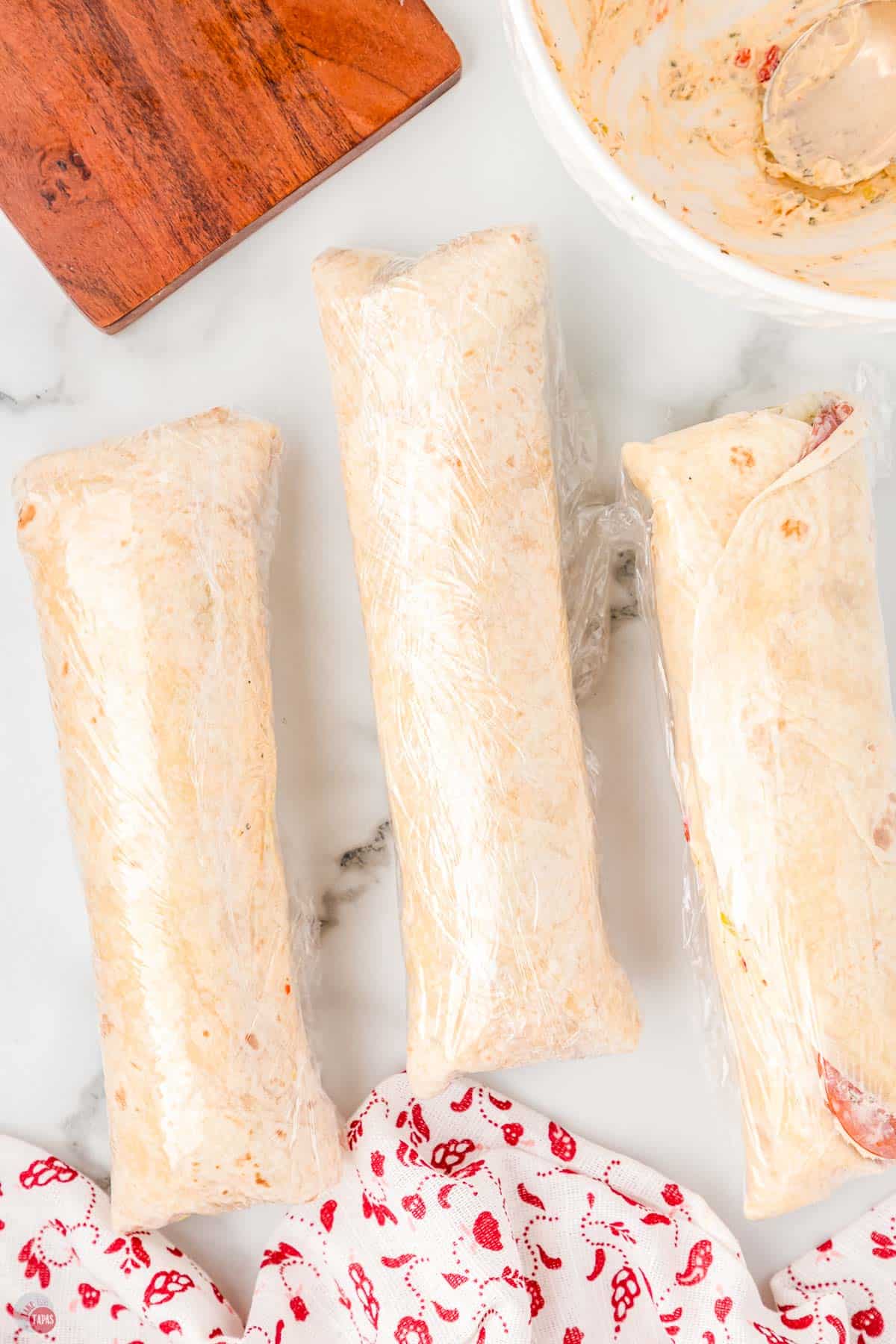 tortilla roll-ups wrapped in plastic wrap