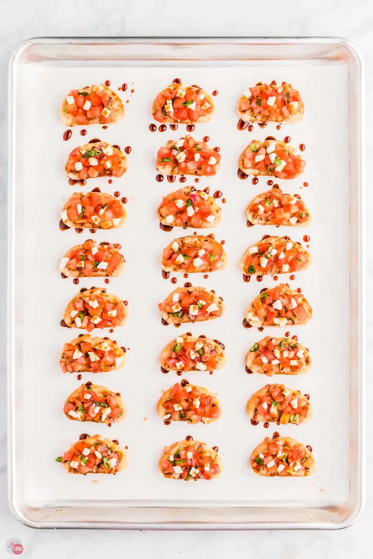 baking sheet with parchment paper and slices of bruschetta
