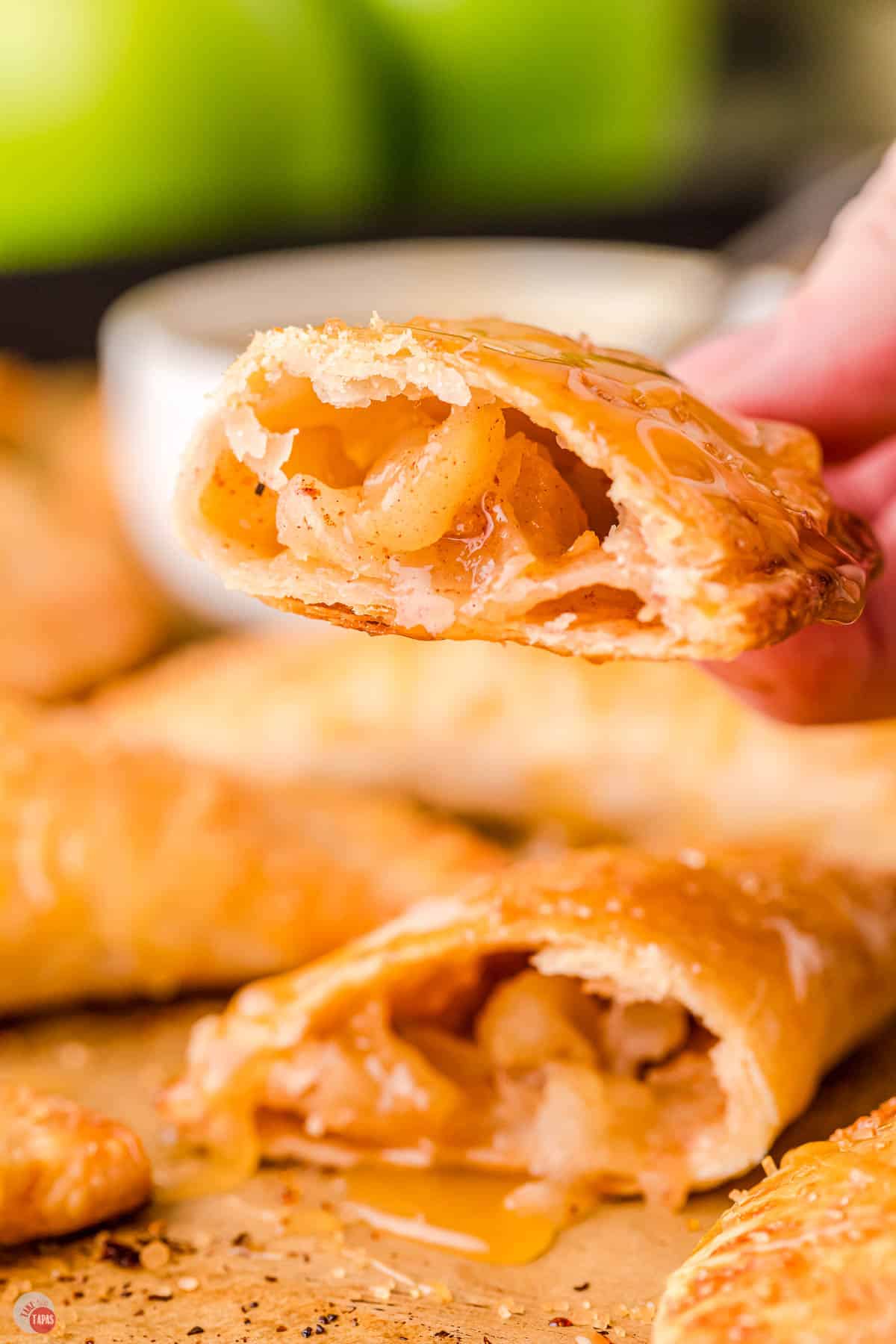 hand holding a caramel apple empanada