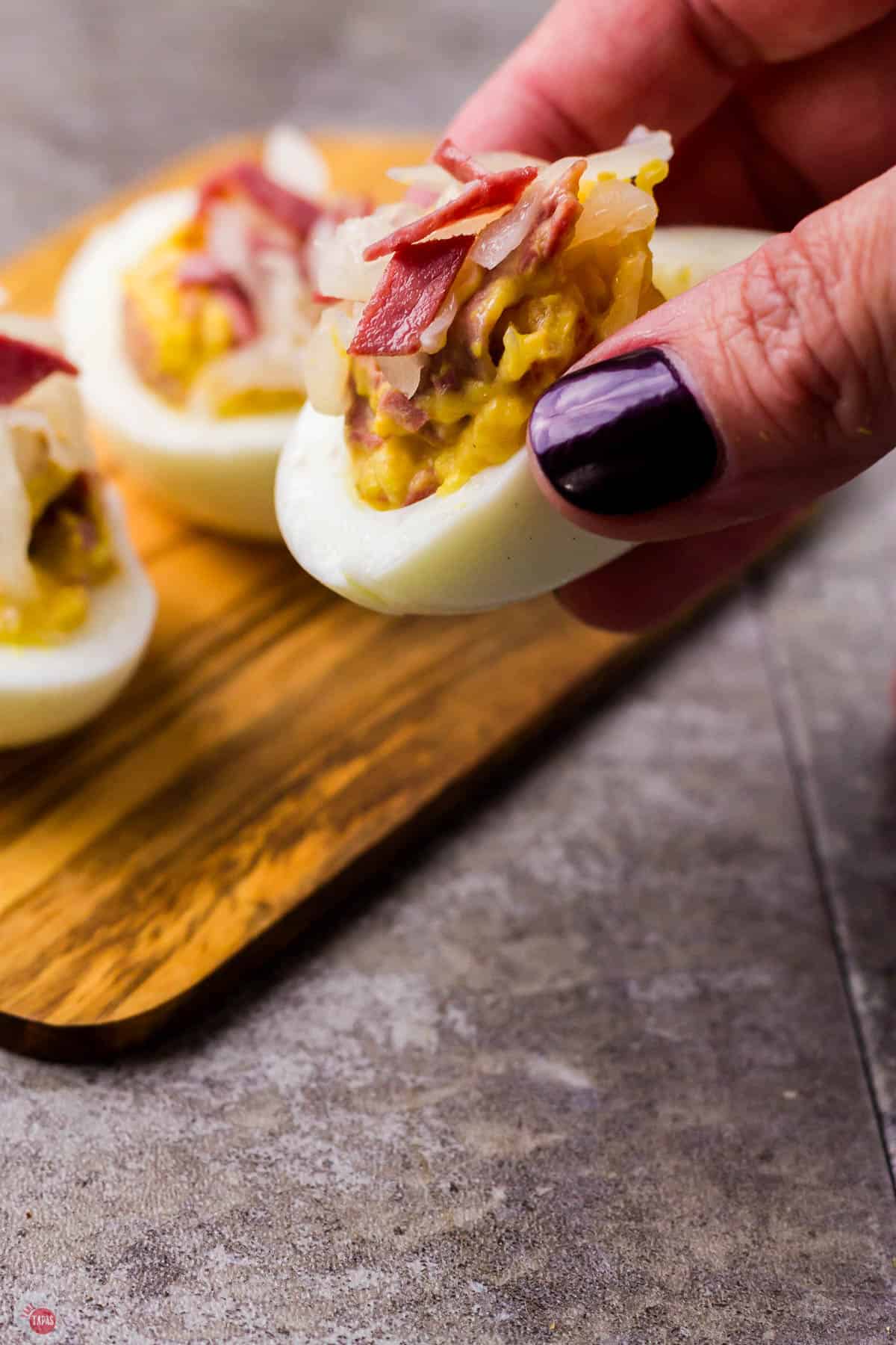 hand holding lots of eggs with corned beef and cabbage