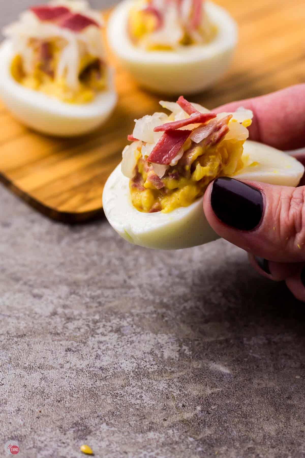 hand with Irish deviled egg in it