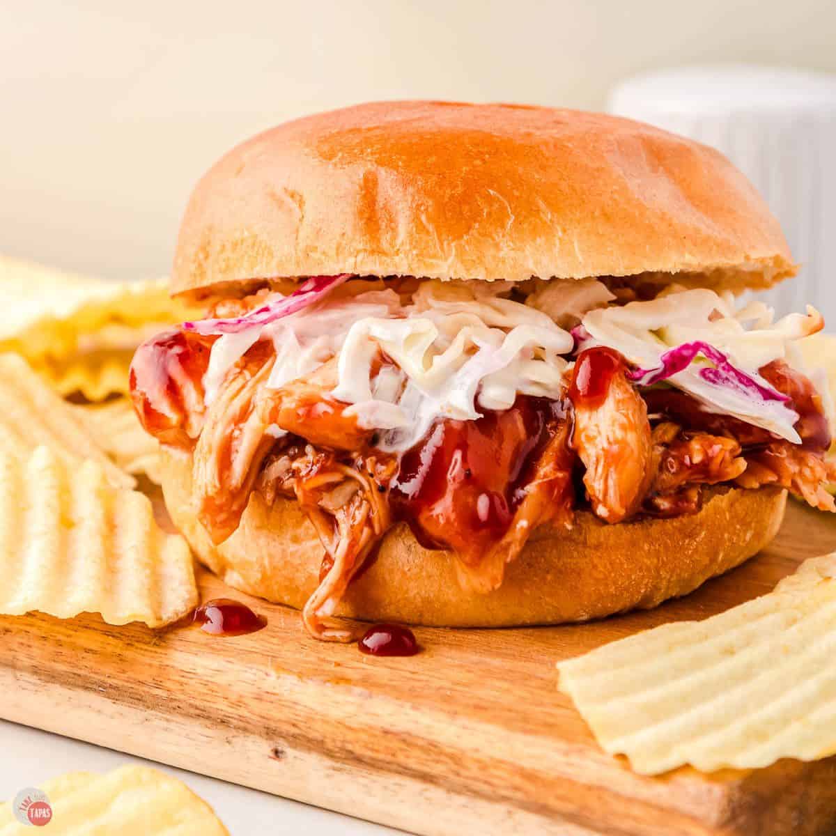 pulled bbq chicken on a bun with chips
