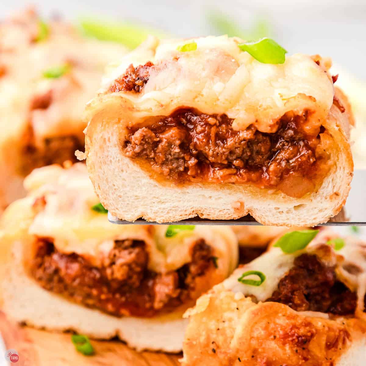 sloppy joe garlic bread slices on a spatula