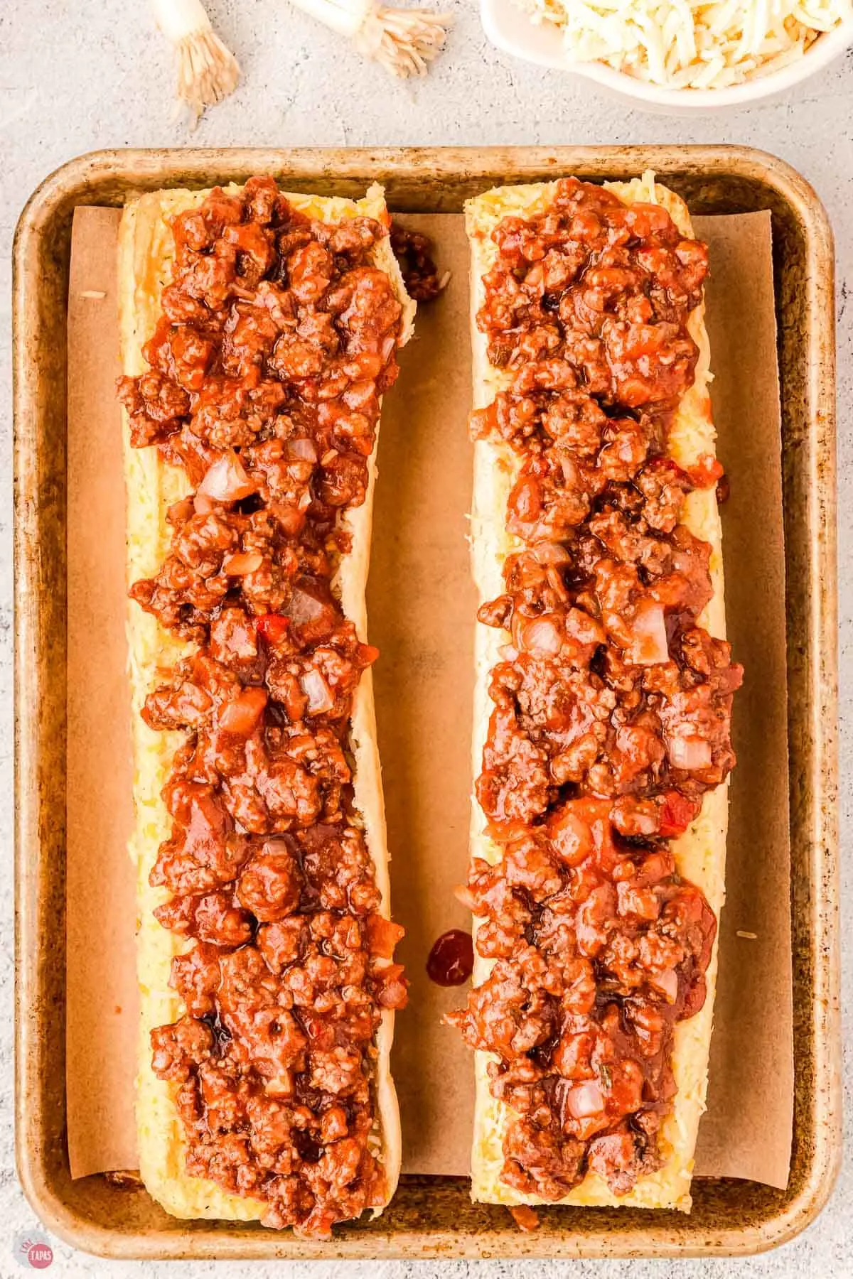 a layer of sloppy joe mixture on top of the garlic bread