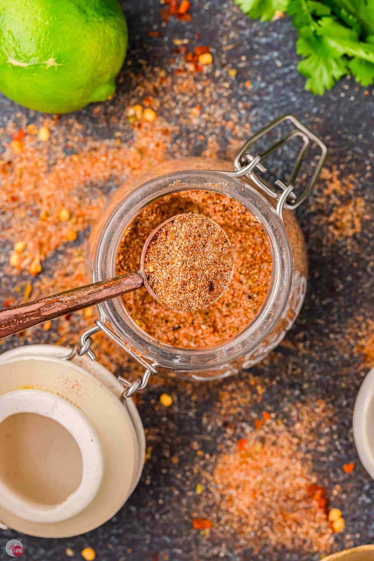 overhead picture of spices in a jar with a copper measuring spoon