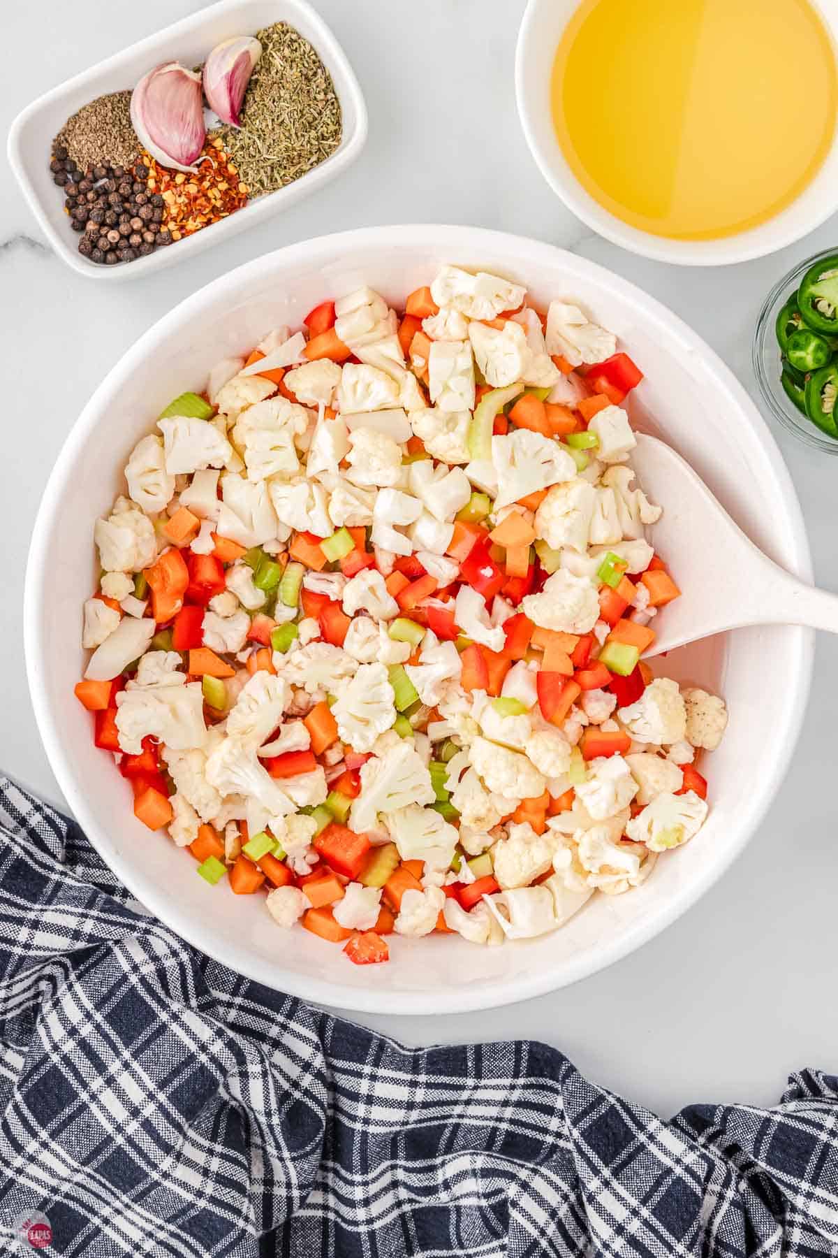 diced cauliflower and carrots in a bowl with brine