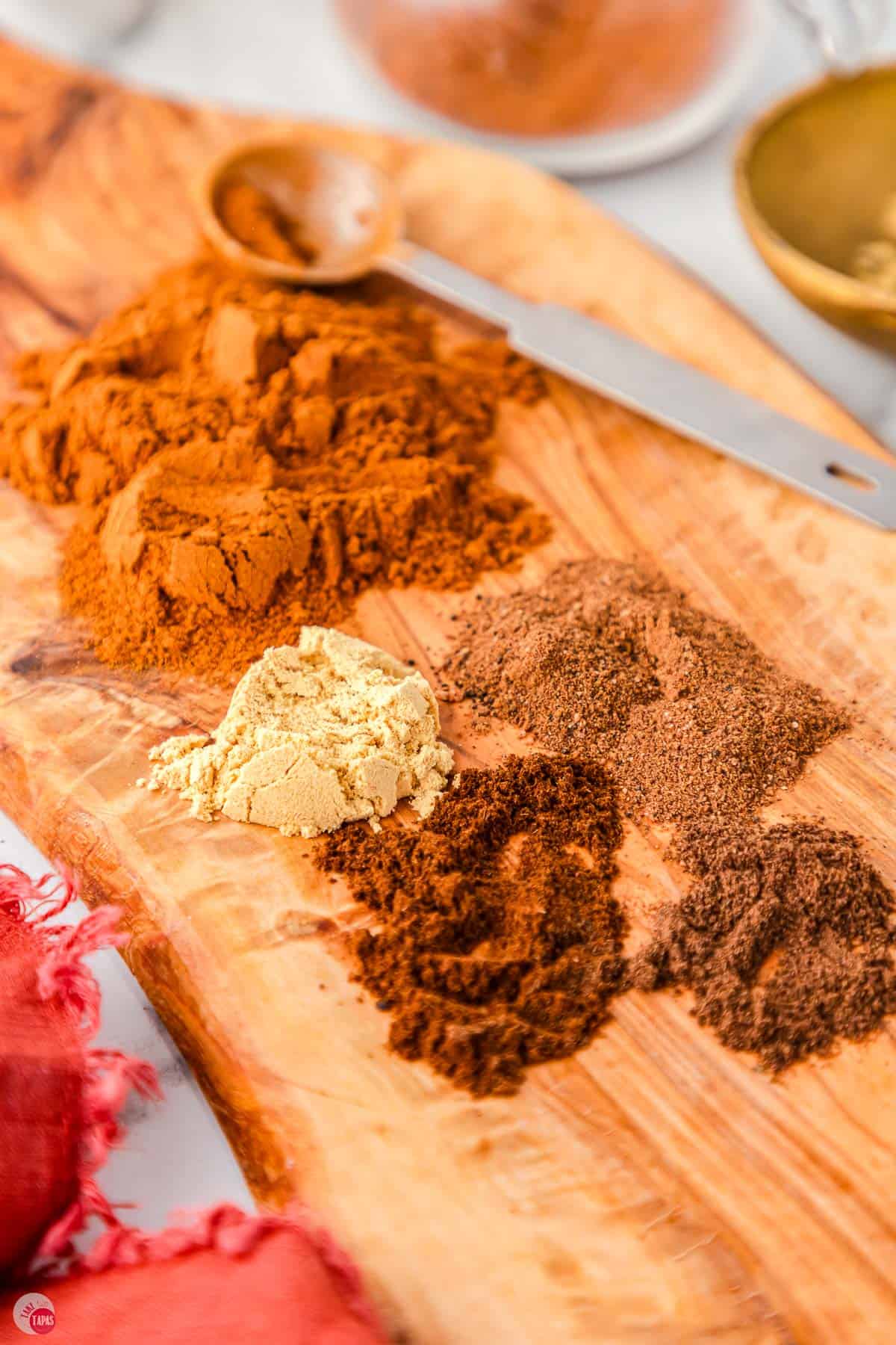 wood board topped with little piles of spices