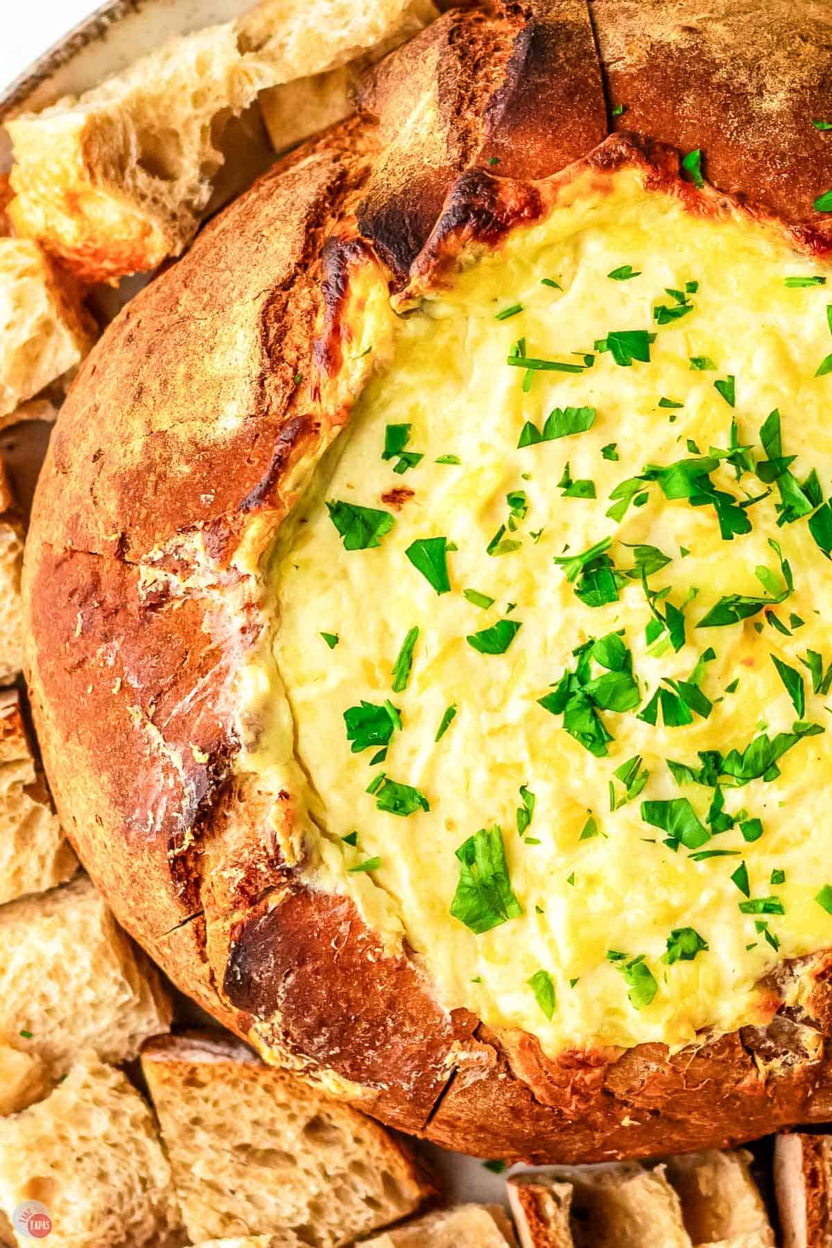 close up of bread bowl with melted cheese dip in it