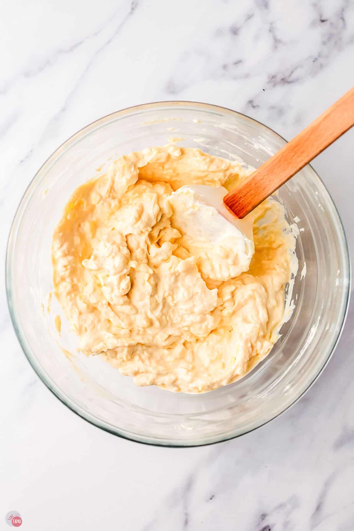 cheese mixture being stirred in a clear bowl