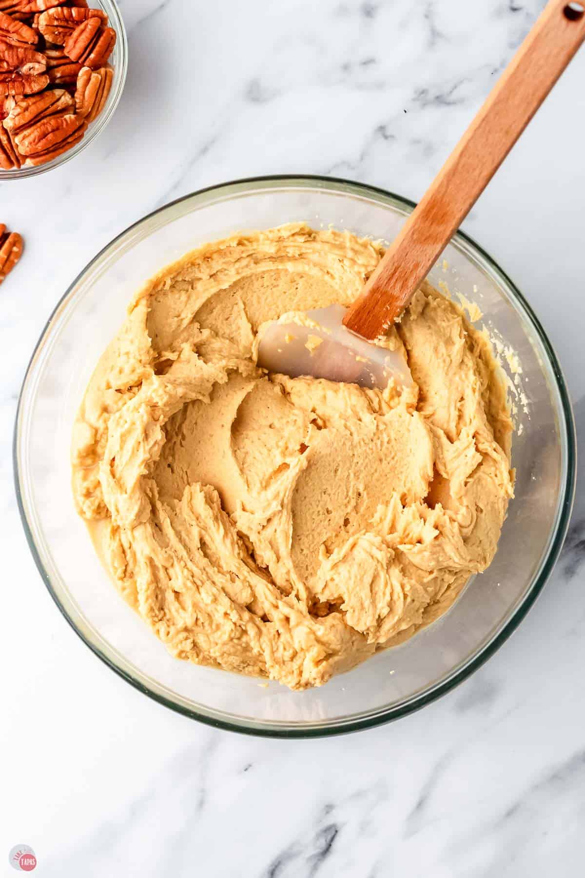 peanut butter mixture in a clear bowl with a spatula