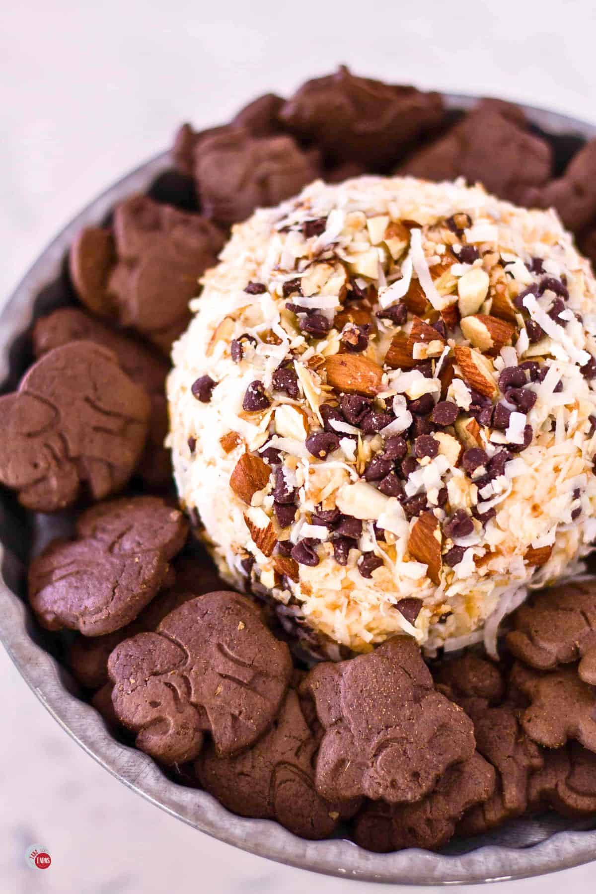 chocolate, coconut, and pecan cheese ball with animal crackers around it