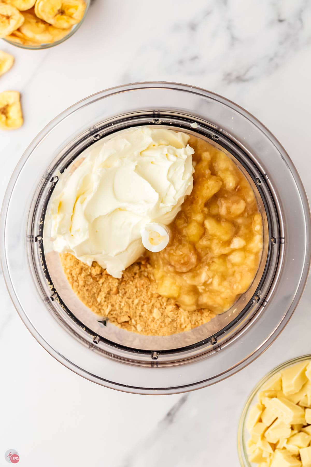 crushed cookie crumbs, cream cheese, and bananas in a food processor bowl