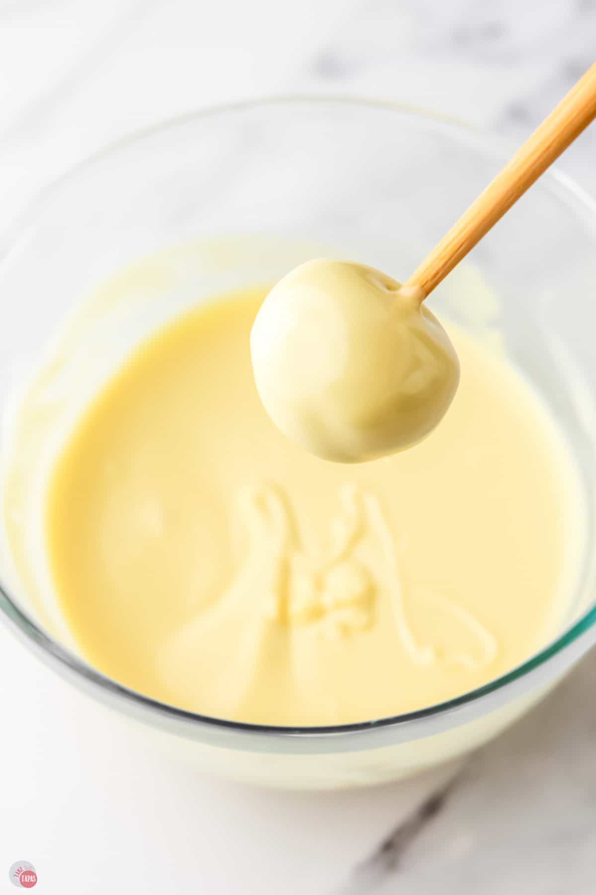 toothpick with a truffle on the end after dipped in white chocolate