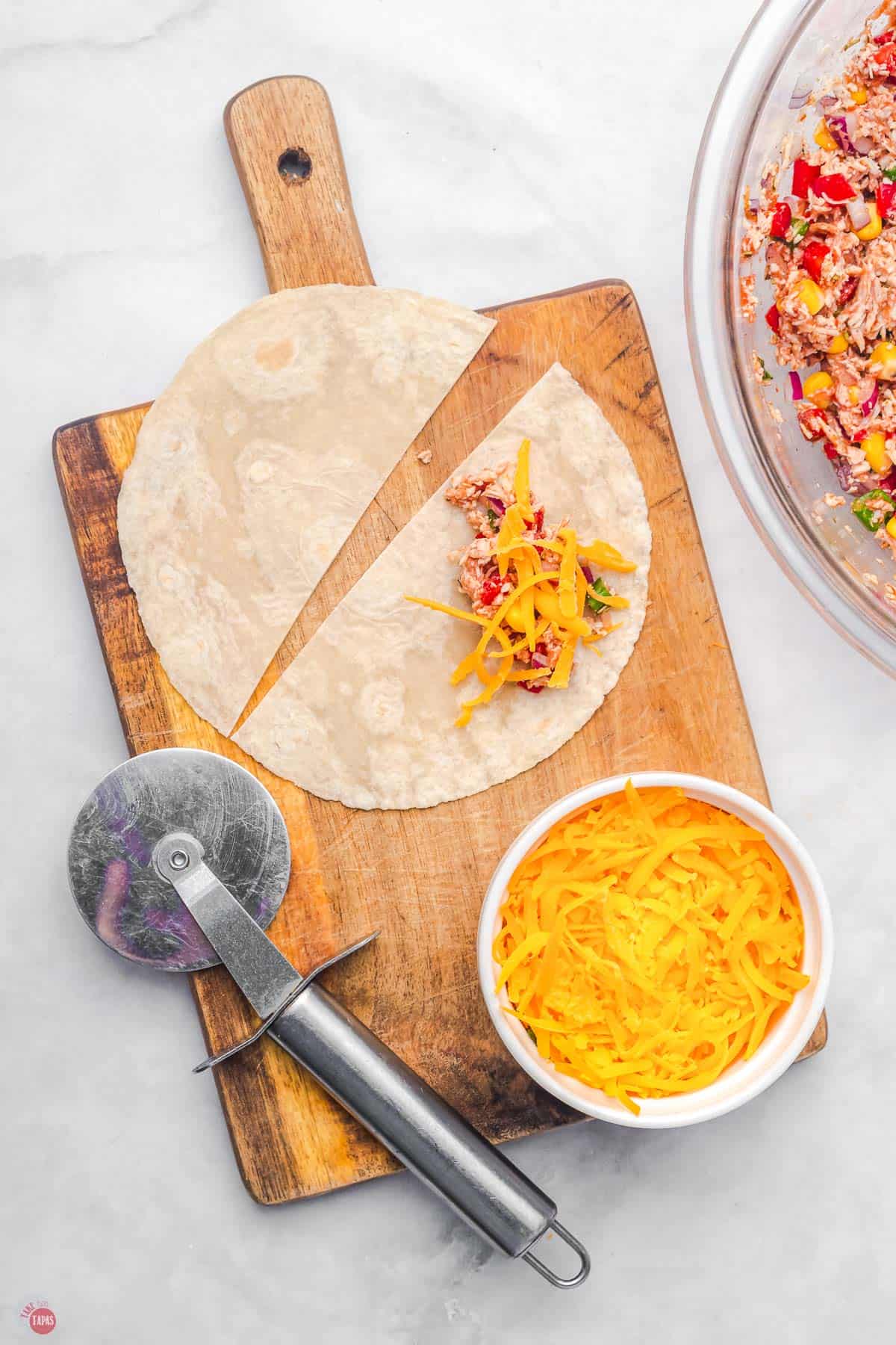 flour tortilla cut in half with with some cheese sprinkled on it