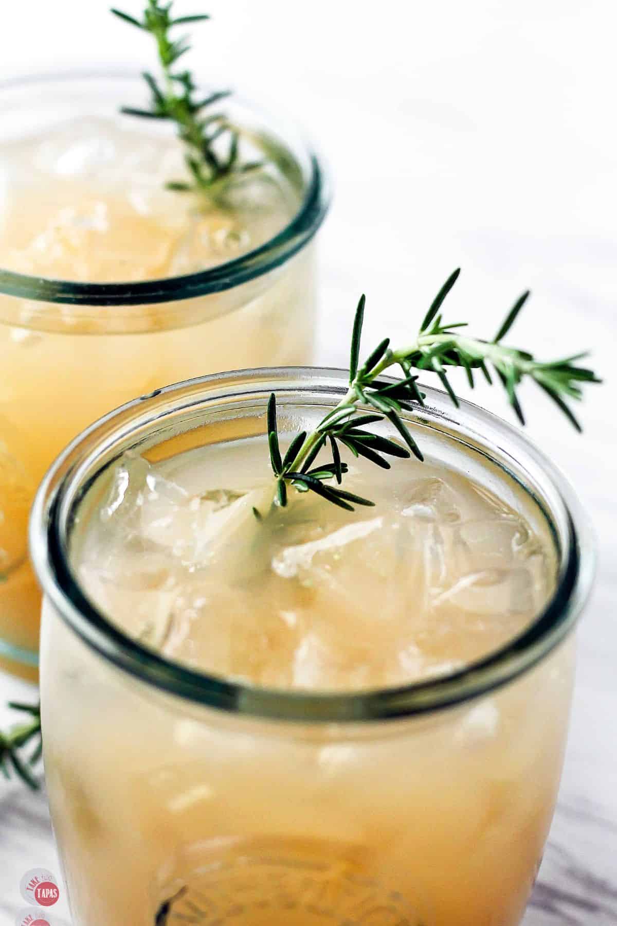 close up of fresh thyme sprig on a glass with juice