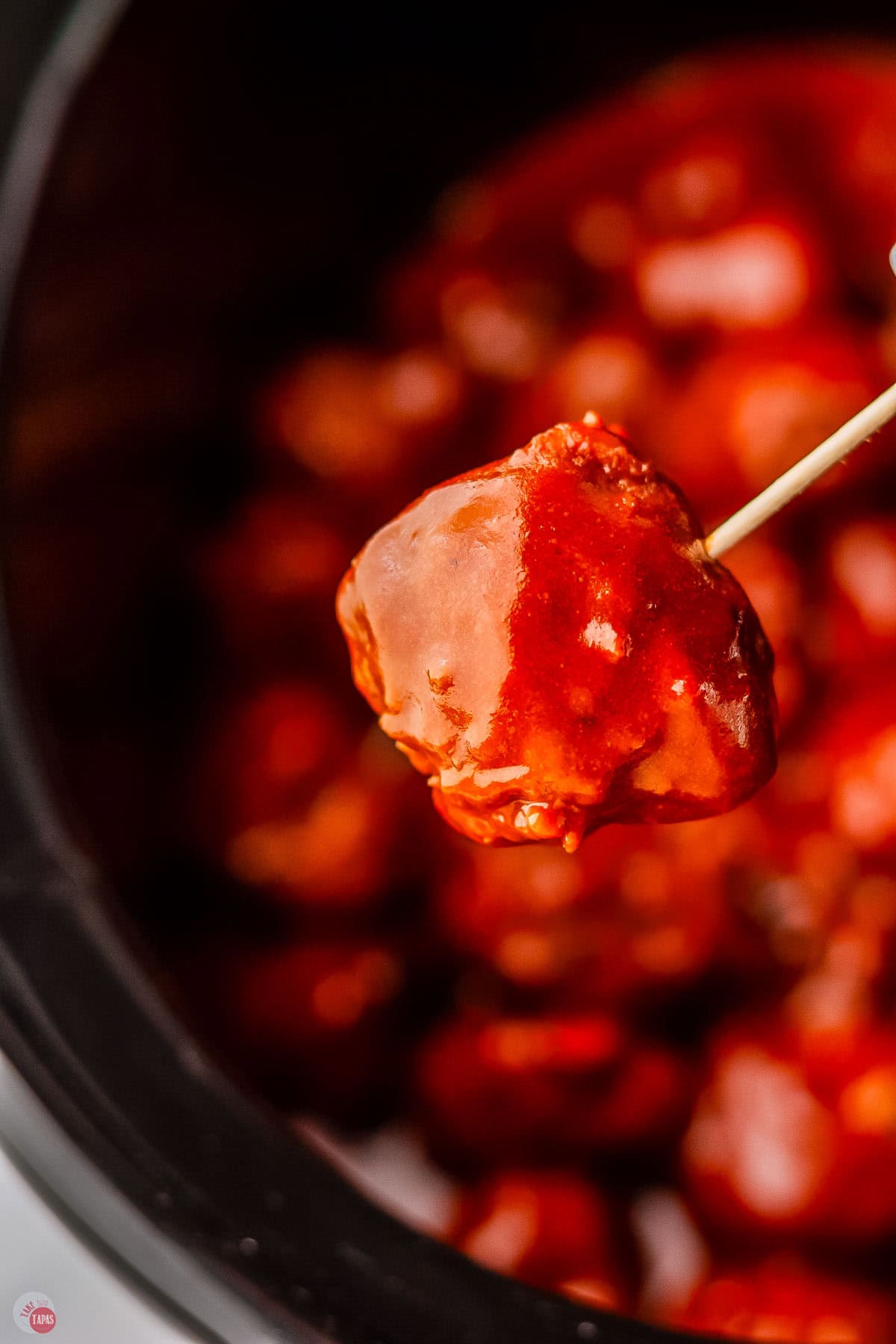 hot honey meatball covered in sauce on a toothpick