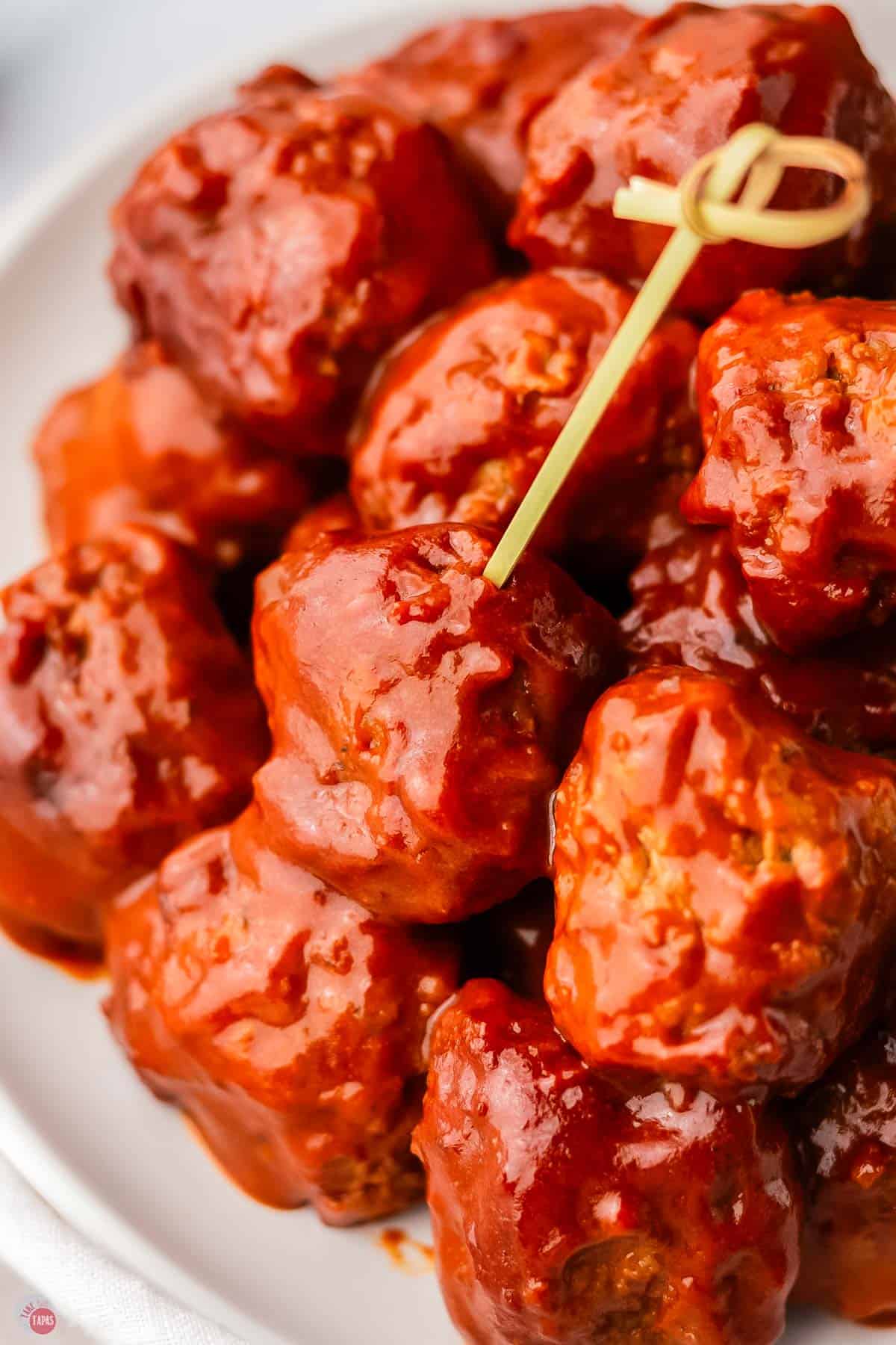 plate of hot honey meatballs with a toothpick in one of them