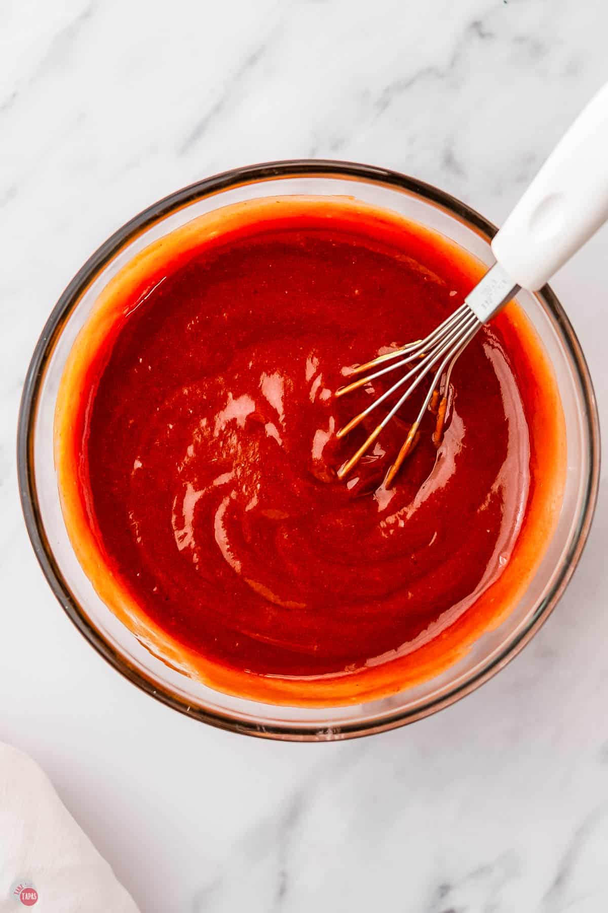 bbq sauce mixing a clear bowl with a whisk