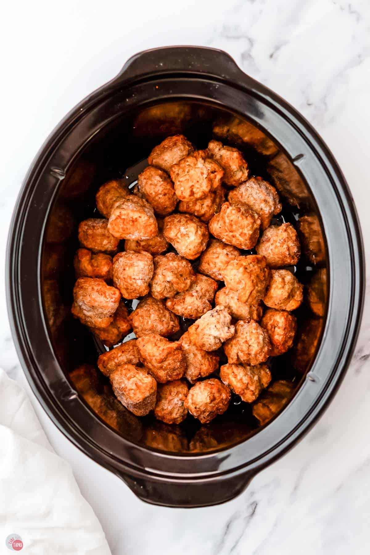 frozen meatballs in a slow cooker pot