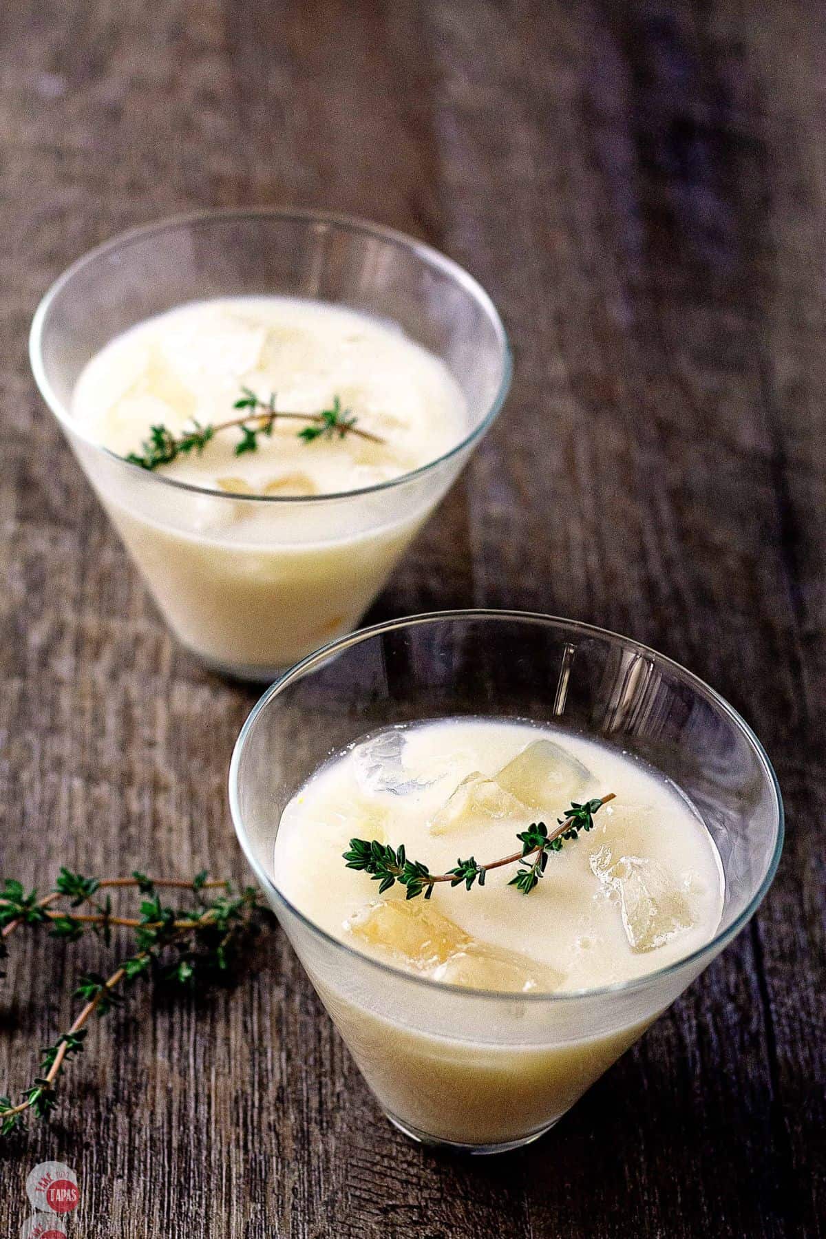 two glasses of lemon drinks with thyme on top