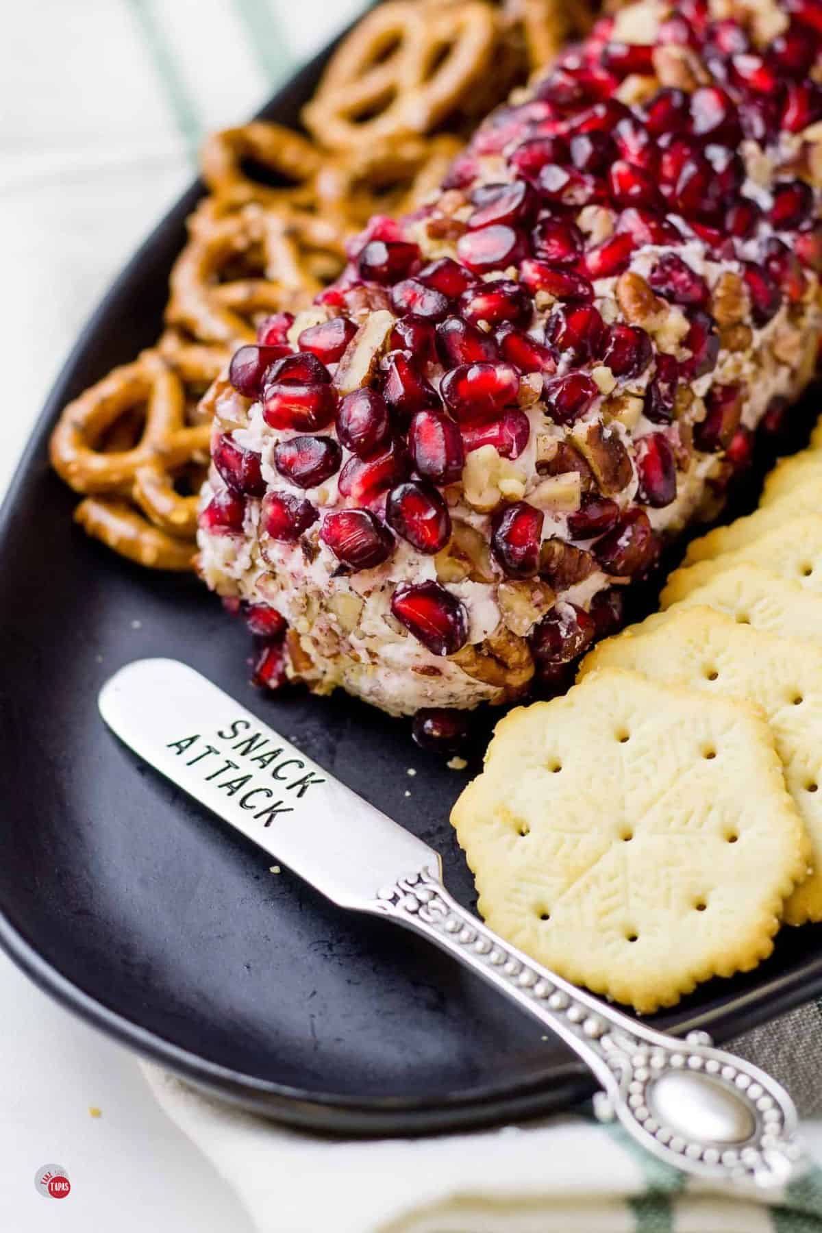 pomegranate cheese log on a black plate