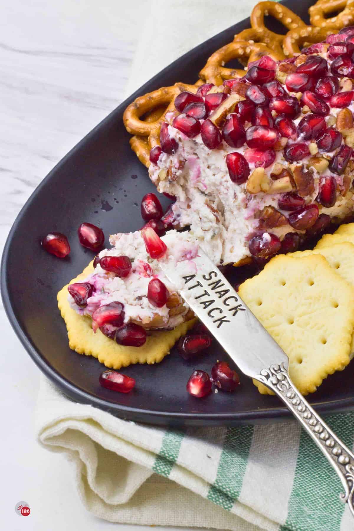 goat cheese and pomegranate seeds on a cracker