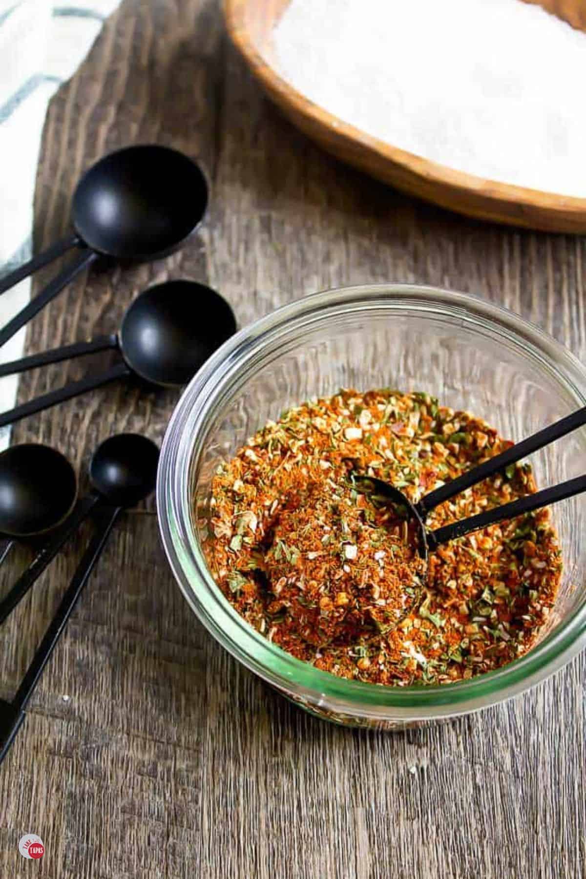 jar of spice mix with a black measuring spoon