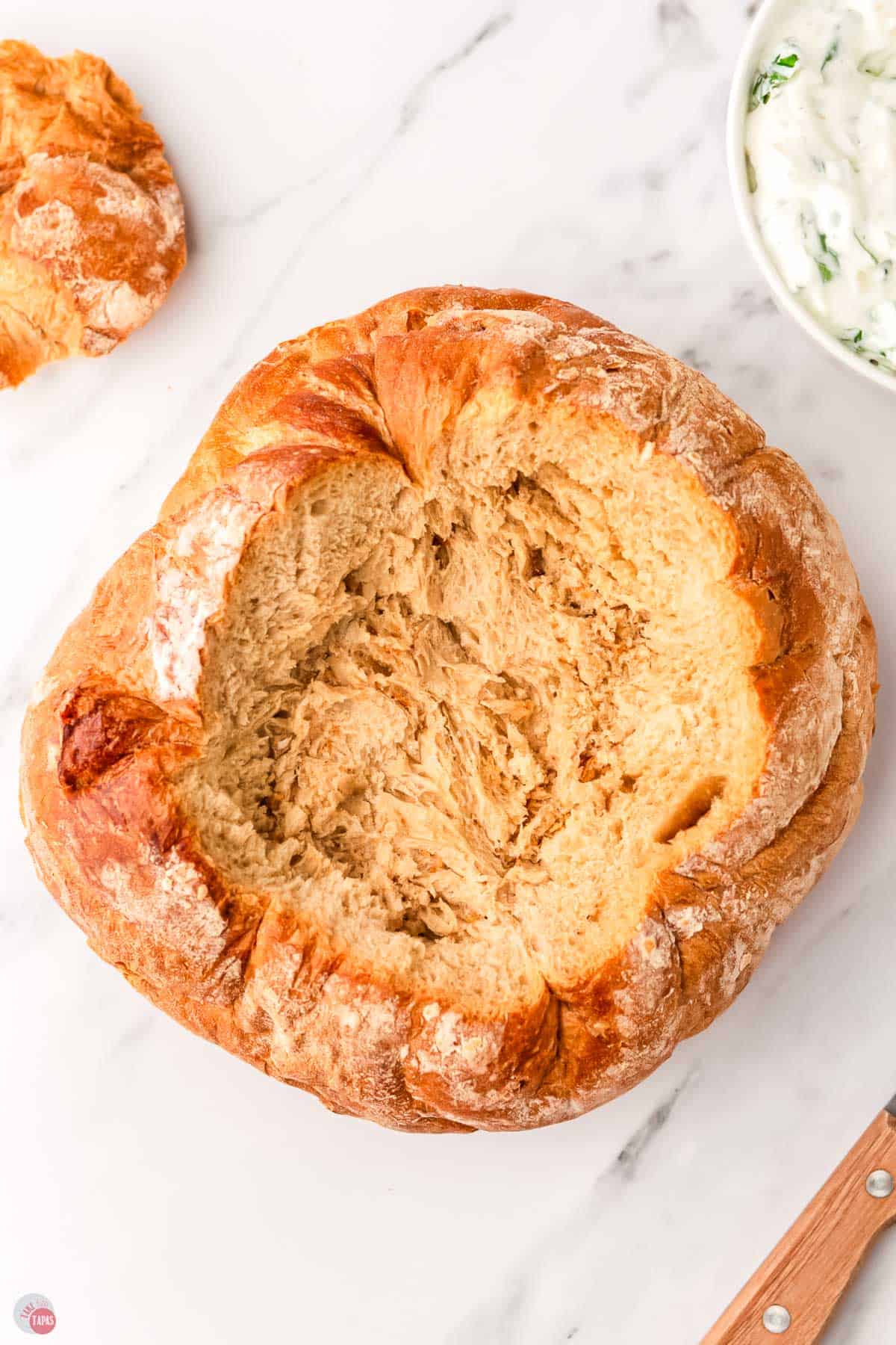 bread loaf with the top removed and the inside hollowed out a little