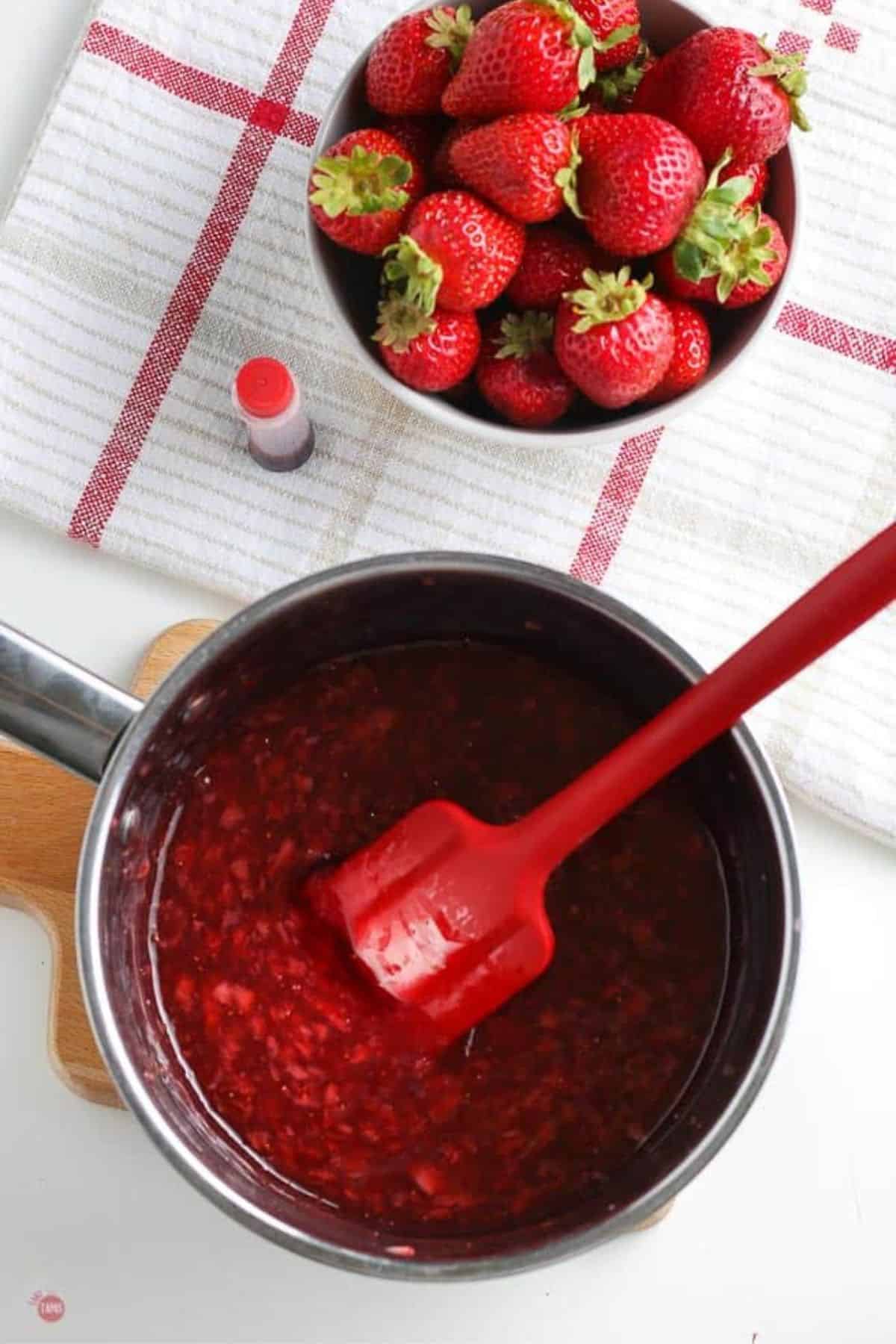 strawberry sauce in a pot with a red spatula
