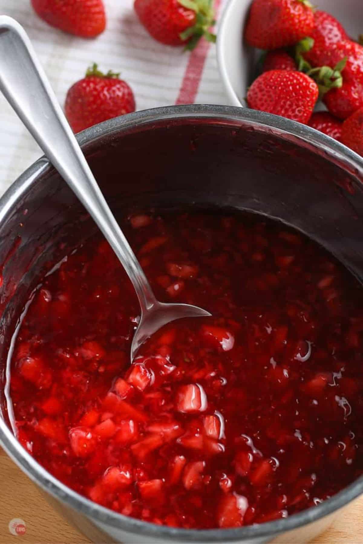 pot of strawberry sauce with red spatula