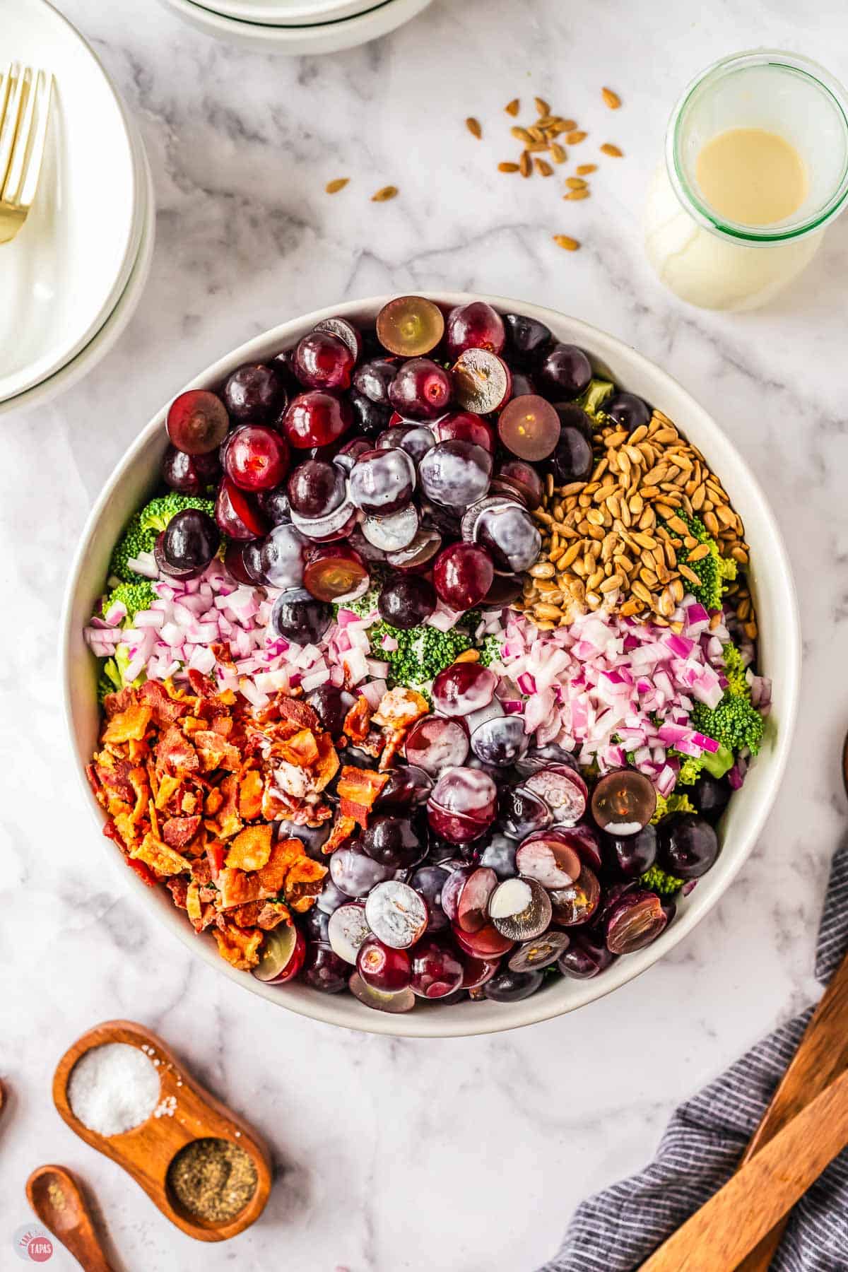 unmixed salad in a white bowl with dressing on top