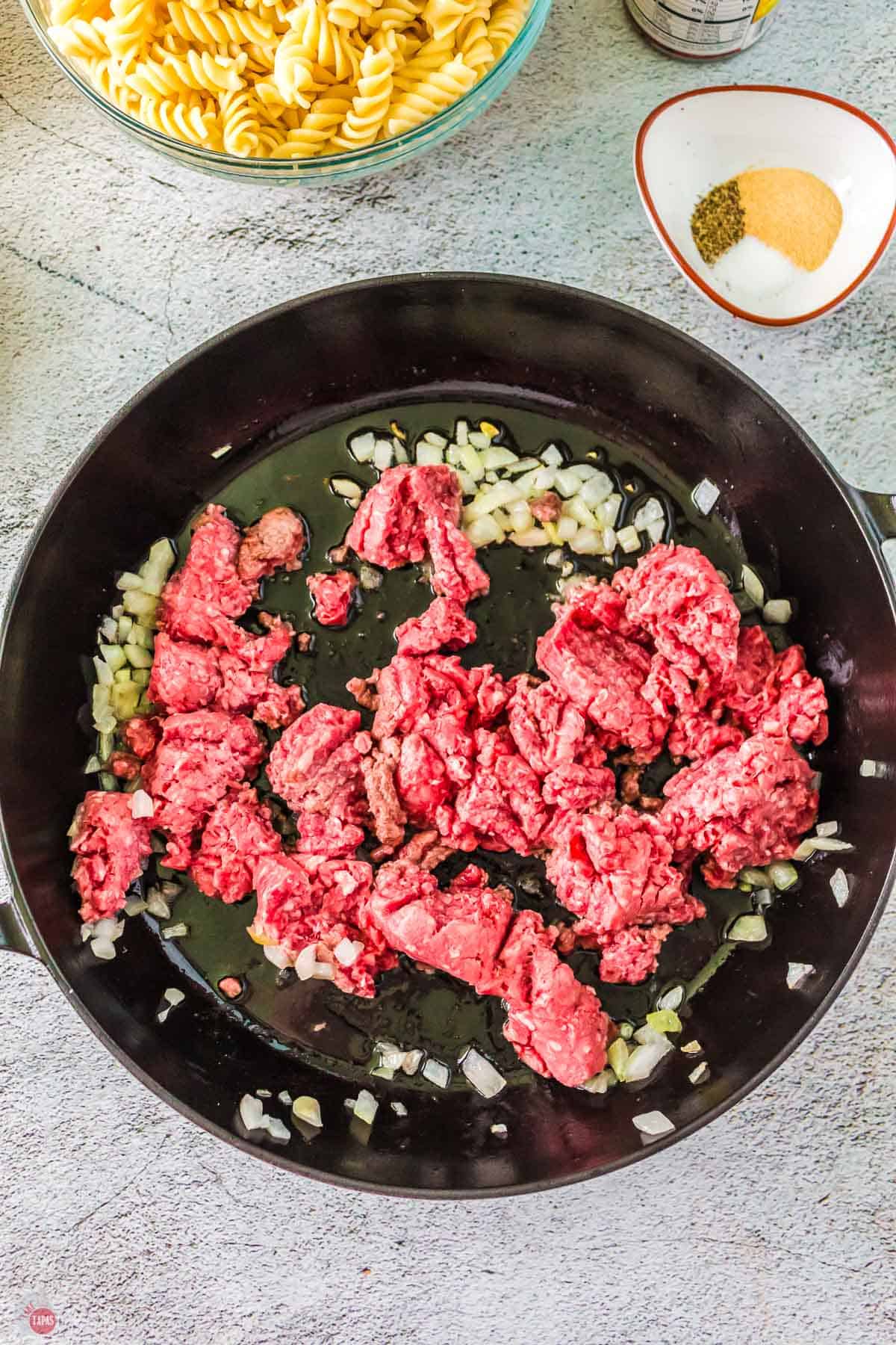 pan with onions and ground beef cooking in it